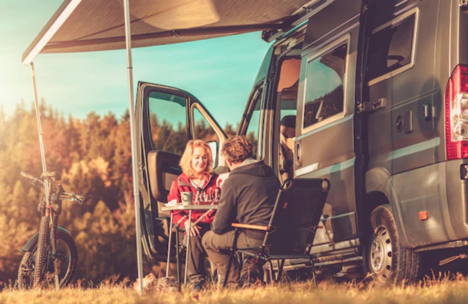 Couple playing chess next to their camper van rv
