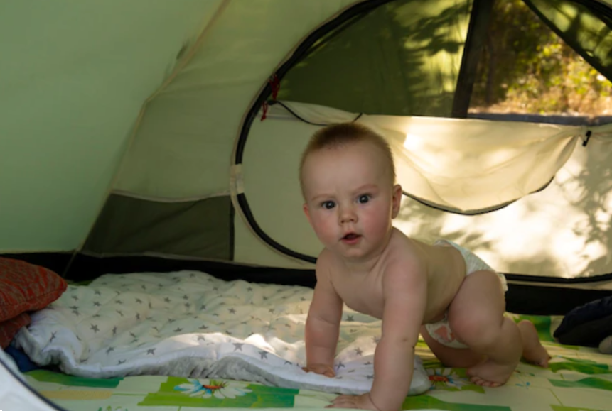 Little baby boy wearing a diaper in a tent