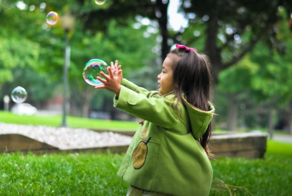 baby girl trying to touch bubbles 