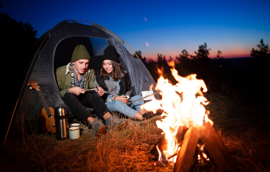 Full shot young couple with bonfire